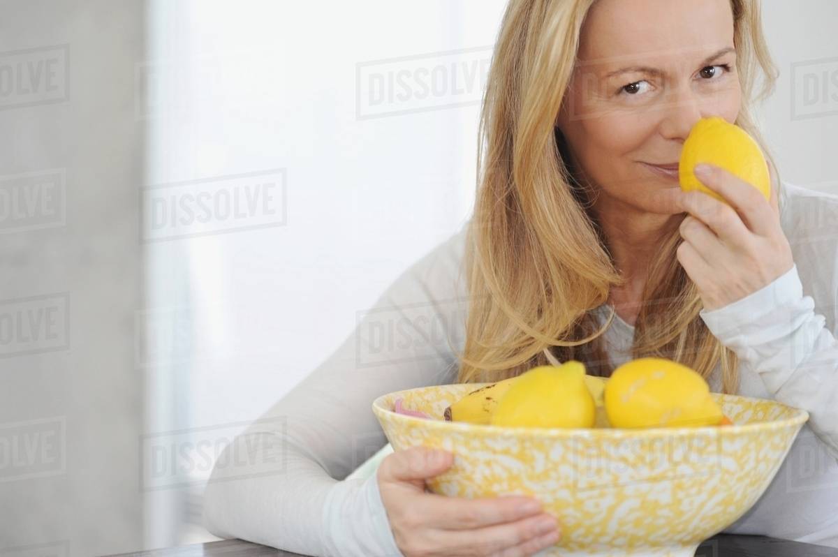 Woman smelling lemons Stock Photo Dissolve