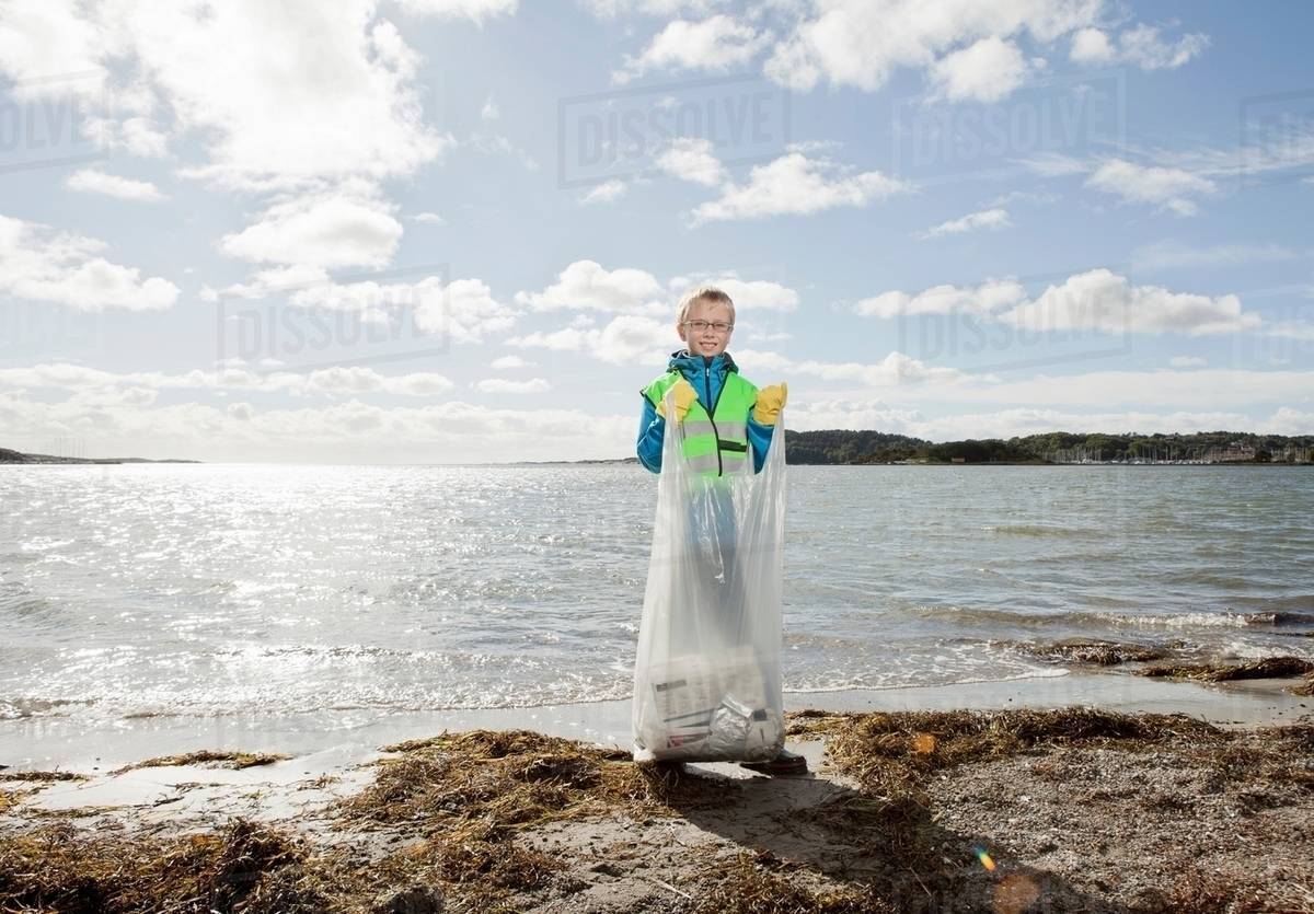 Boy in safety vest cleaning beach Stock Photo Dissolve
