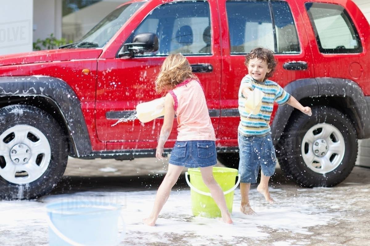 Children playing and washing car Stock Photo Dissolve