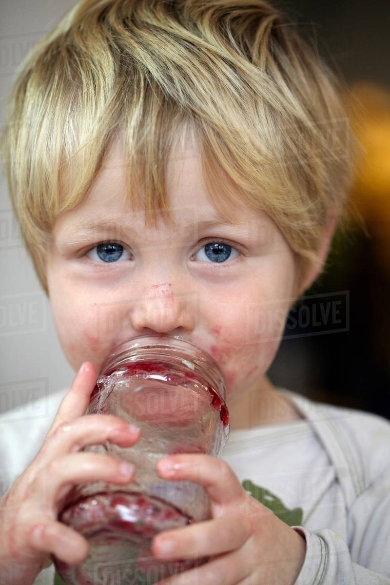 Boy eating jam from jar Stock Photo Dissolve
