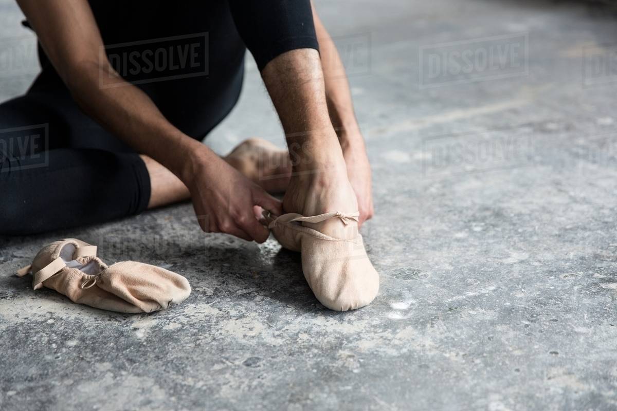Dancer wearing ballet shoe in studio Stock Photo Dissolve