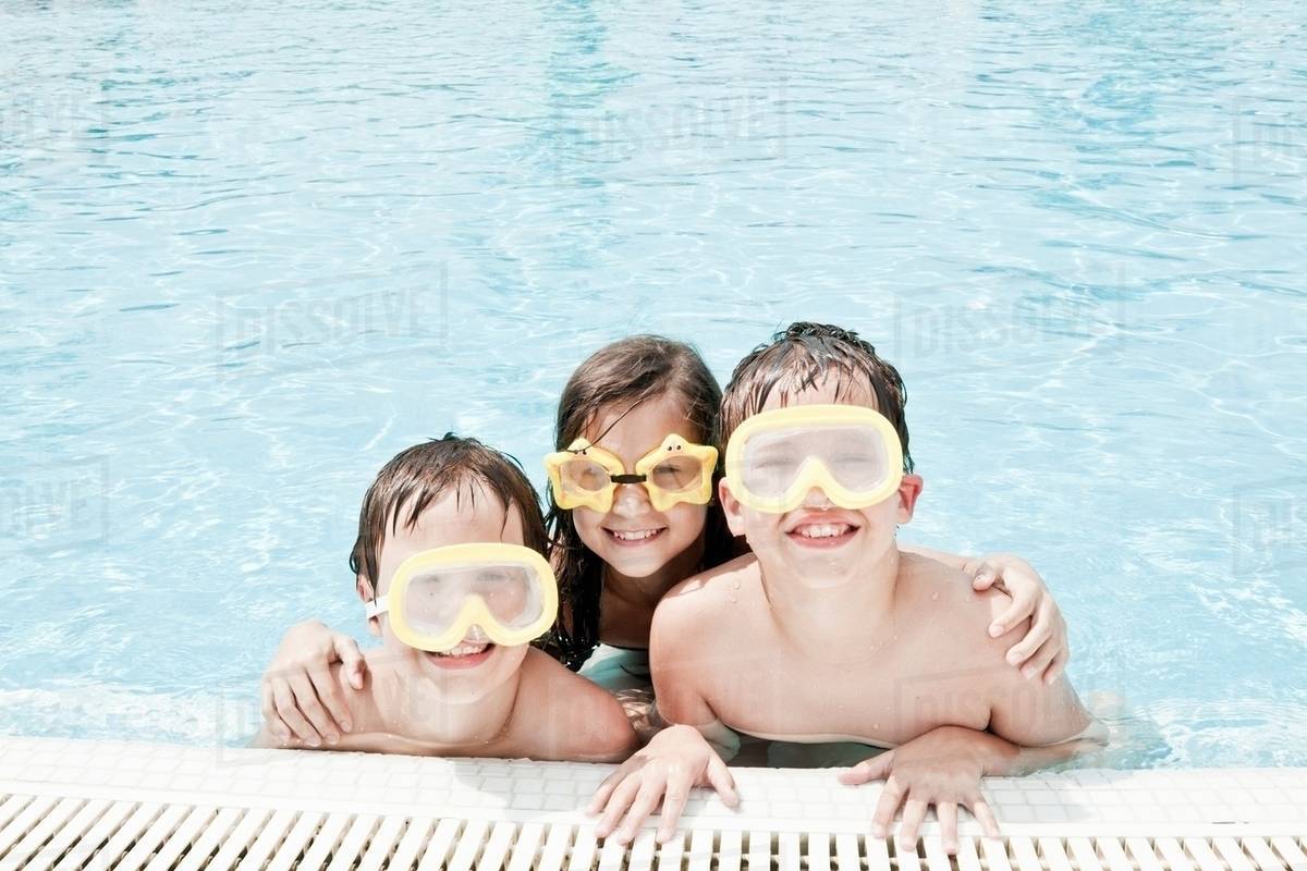 Children in pool wearing swimming goggle Stock Photo Dissolve