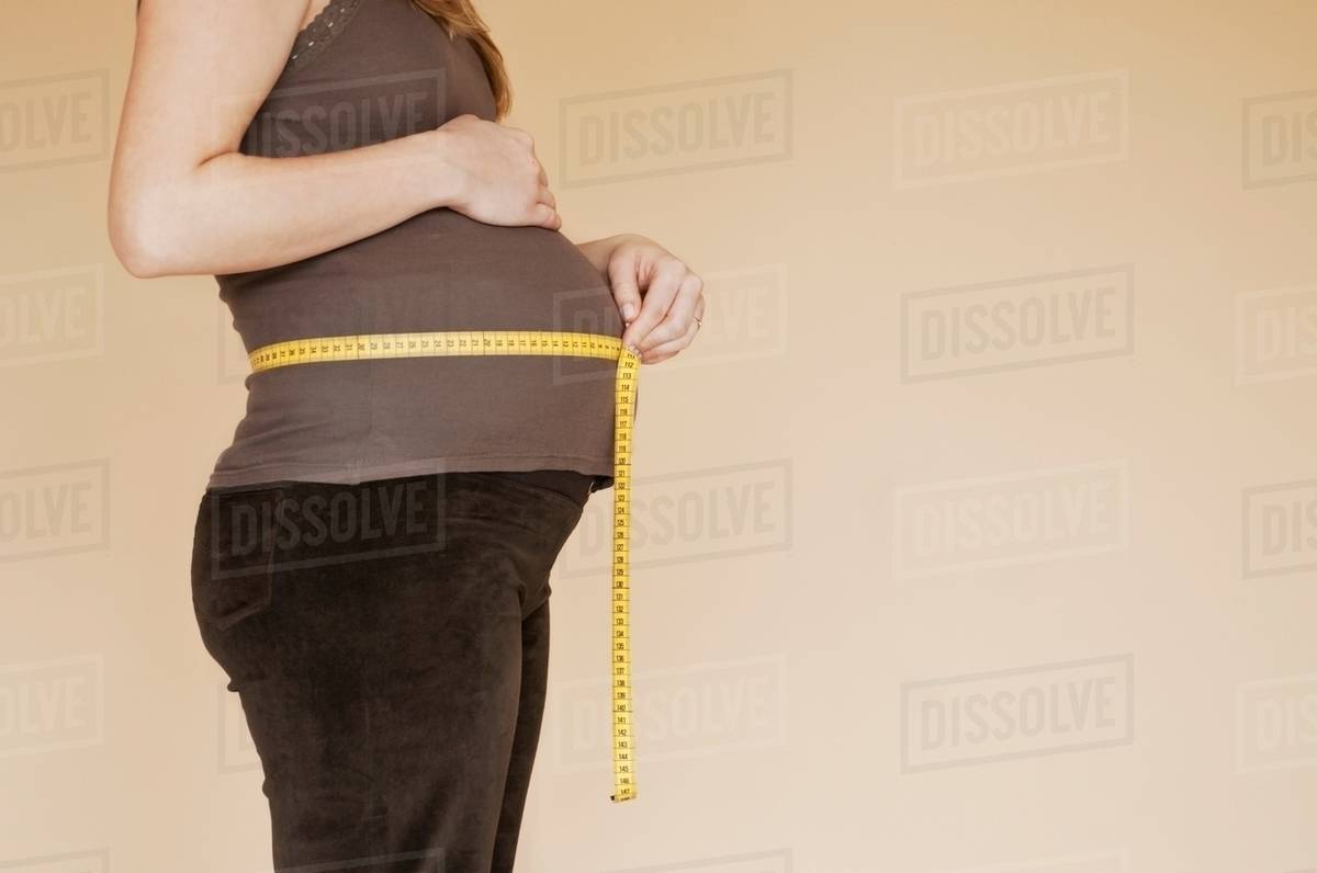 Pregnancy bump with  measuring tape, profile Royalty-free stock photo