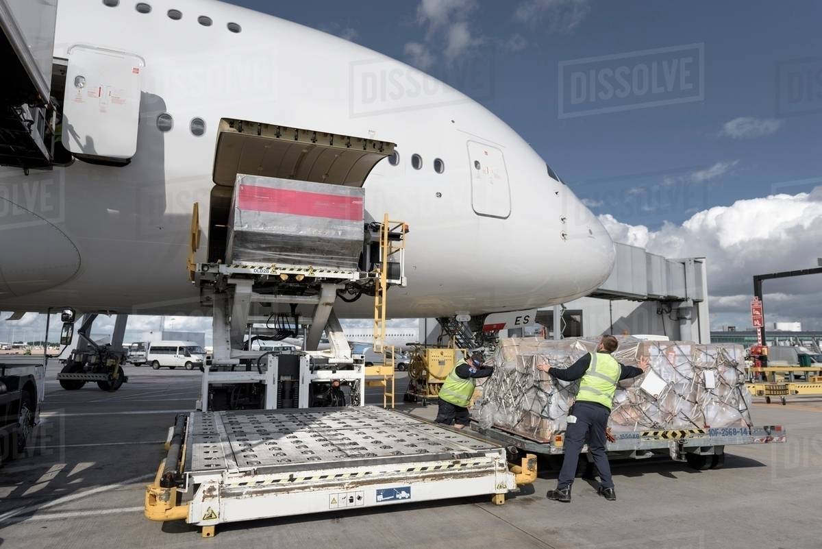 Ground crew loading freight into A380 aircraft Stock Photo Dissolve