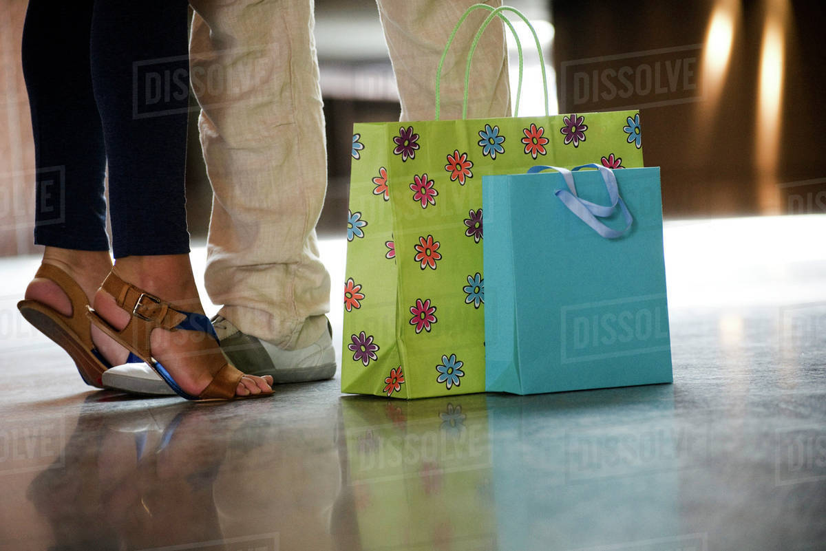 Shopping Bags On The Floor By Couple S Legs Low Section Stock