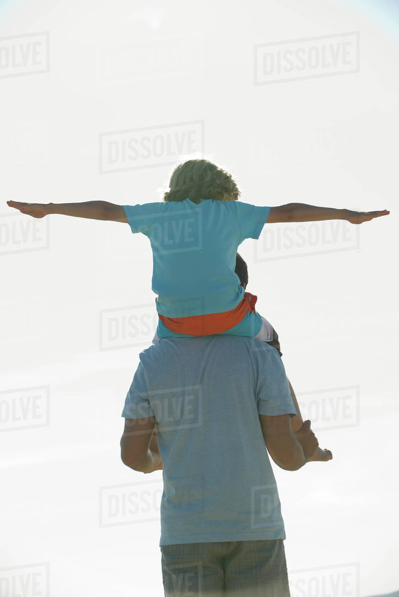 Boy riding on father's shoulders, rear view - Royalty-free Stock Photo ...