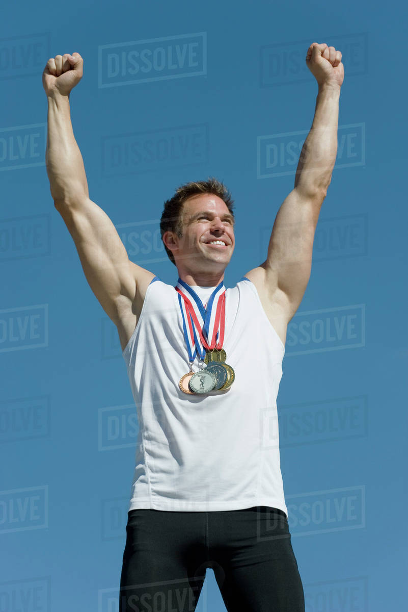 Male athlete with arms raised in victory Stock Photo Dissolve