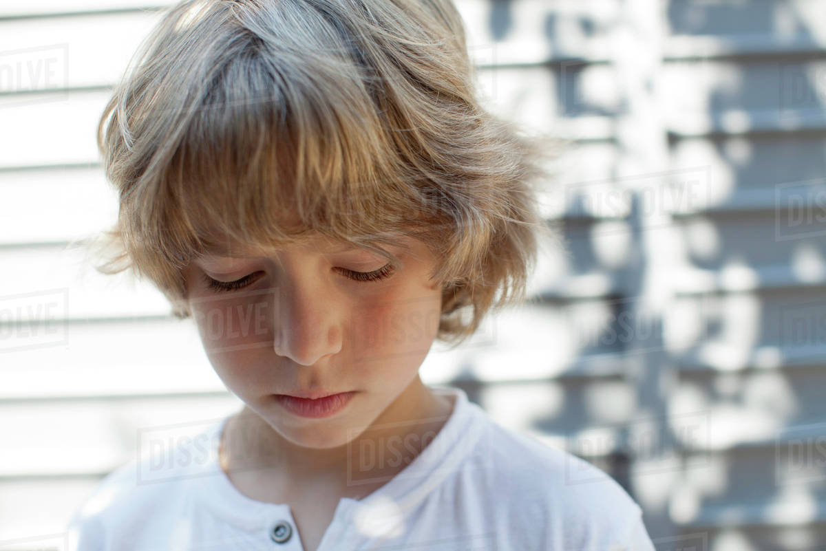 Boy looking down, portrait Stock Photo Dissolve