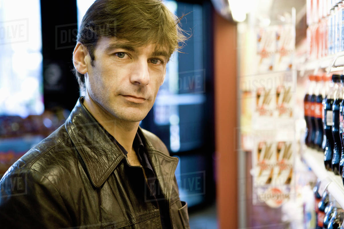 Man at soft drink cooler in convenience store Stock Photo Dissolve