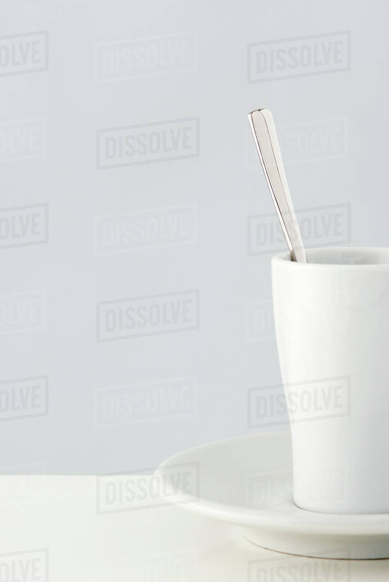 Coffee cup and spoon, closeup, cropped Stock Photo Dissolve