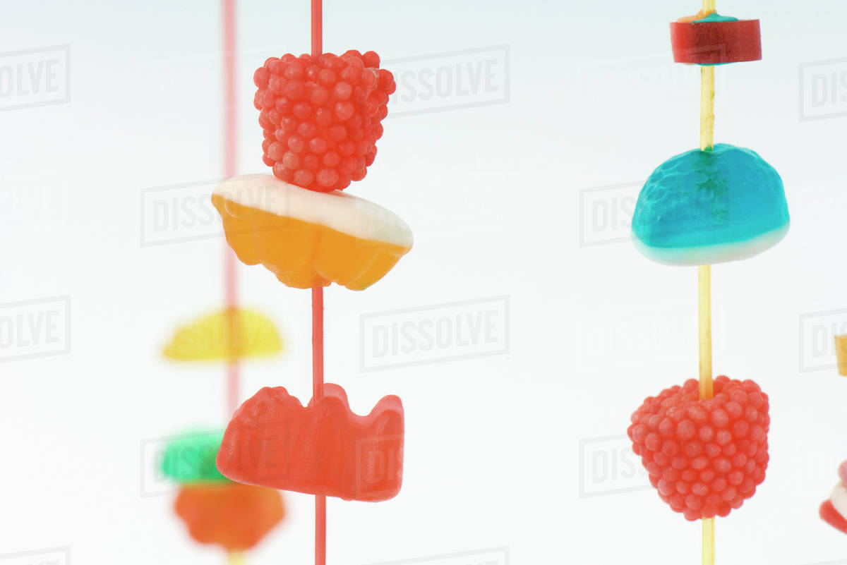 Colorful candy hanging on strings, closeup Stock Photo Dissolve