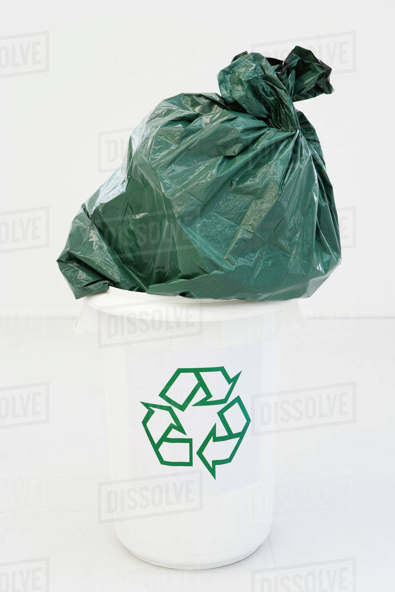 Excessively Large Garbage Bag Stuffed Partially Into Recycling Bin Excessively Large Garbage Bag Stuffed Partially Into Recycling Bin