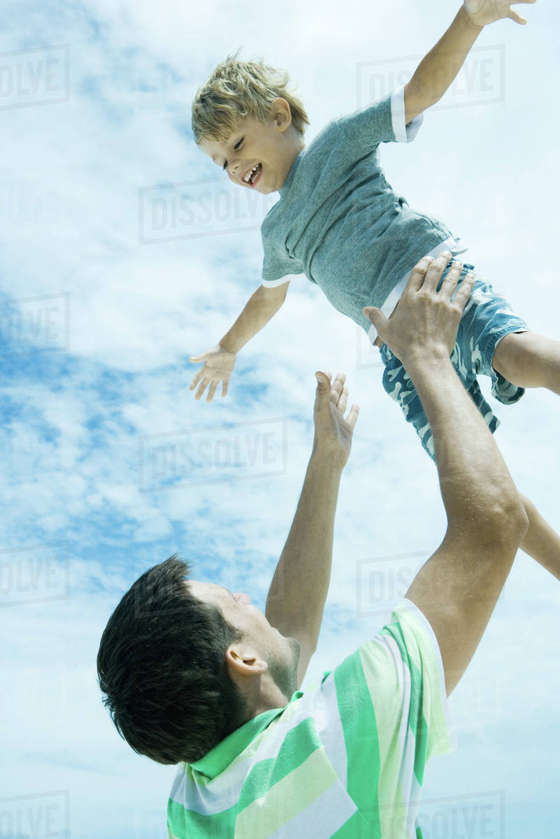 Man throwing child into air Stock Photo Dissolve