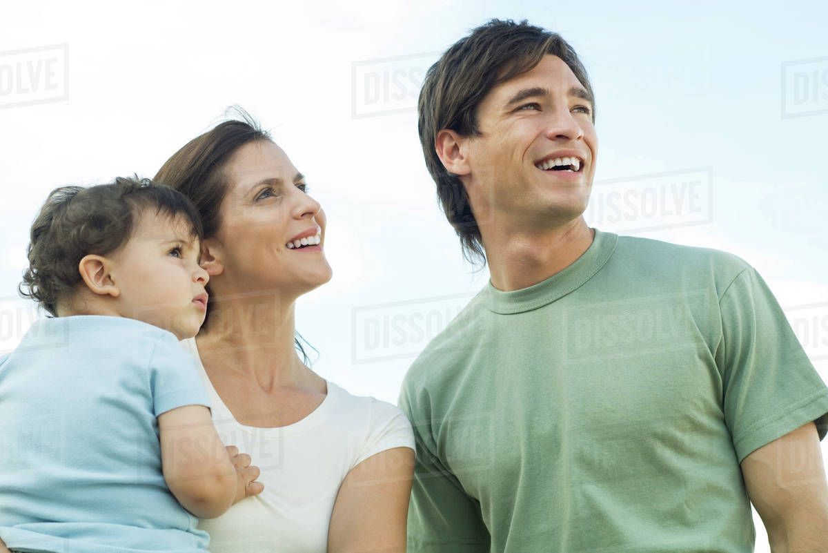 Family looking up, mother holding baby Stock Photo Dissolve