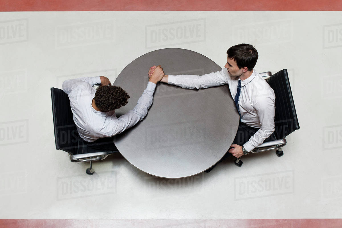 Businessman Defeats Colleague At Arm Wrestling Match Stock Photo
