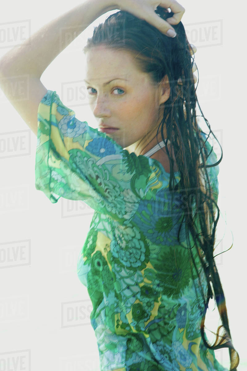 Woman With Long Wet Hair Hand On Head Looking Over Shoulder At