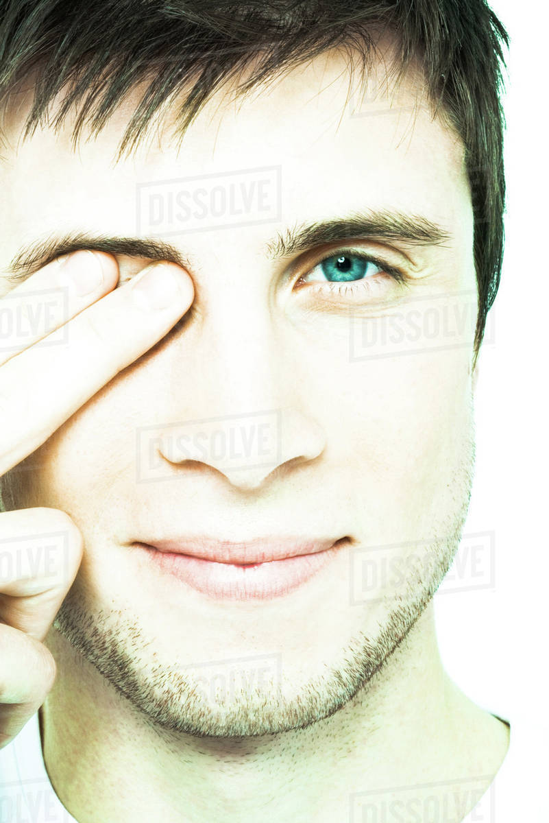 young man holding fingers over eye close up front view of face