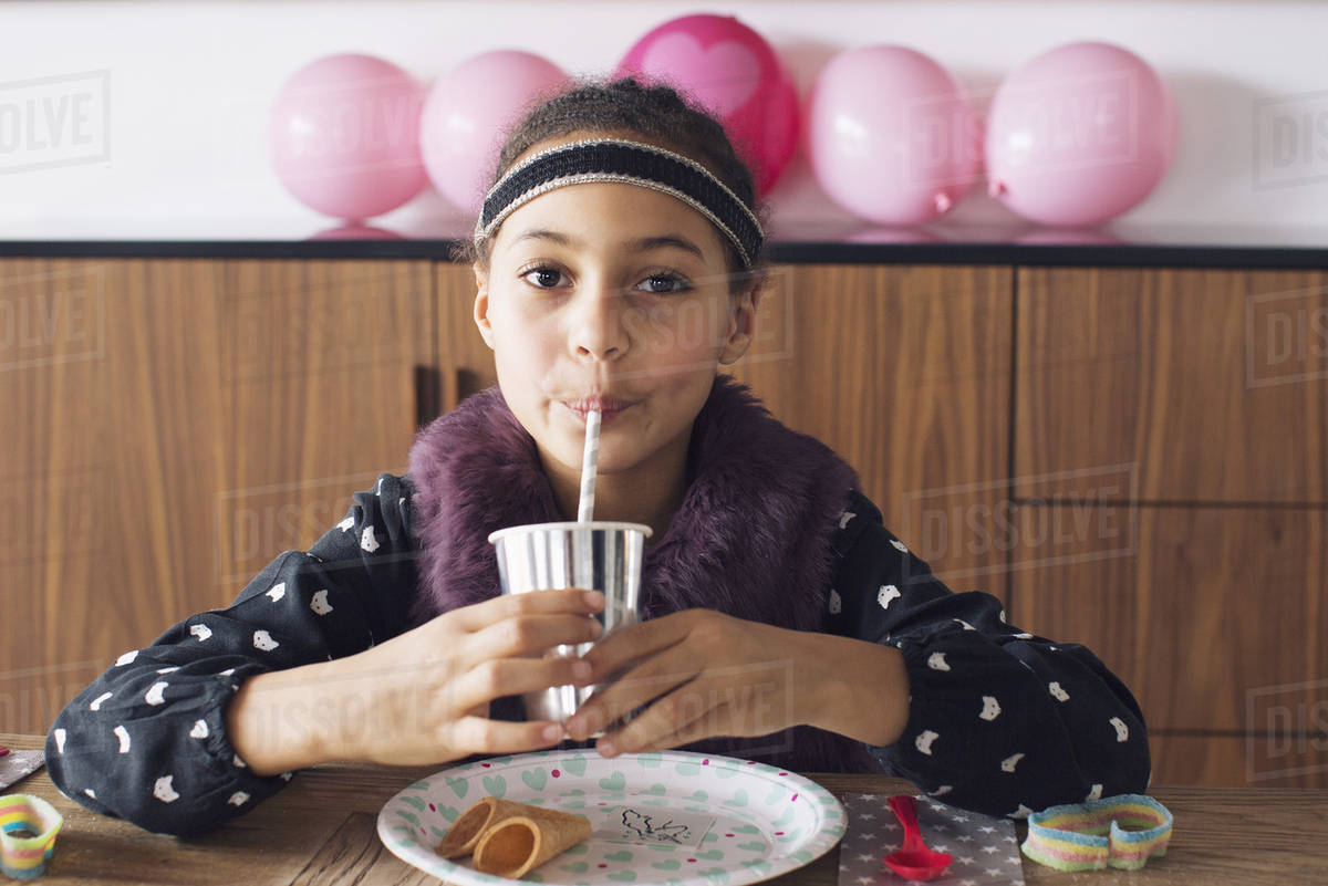 Girl drinking through a straw Stock Photo Dissolve