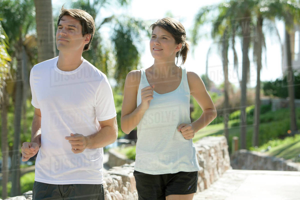 Couple jogging together in park Stock Photo Dissolve
