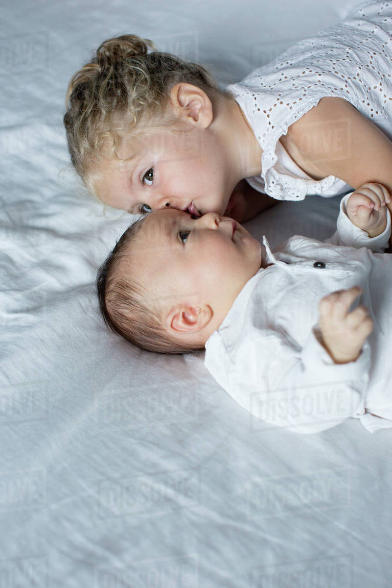 Little girl cuddling with baby brother Stock Photo Dissolve