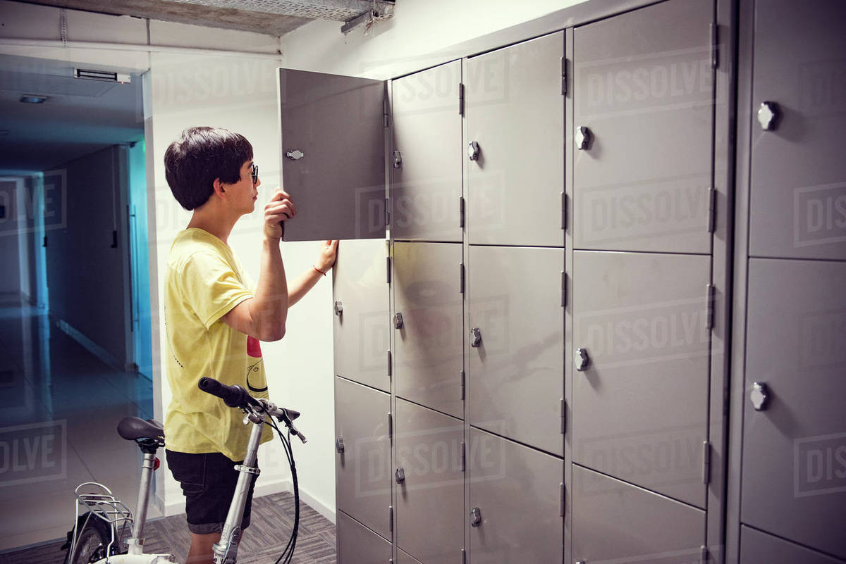College student opening locker in corridor Stock Photo Dissolve
