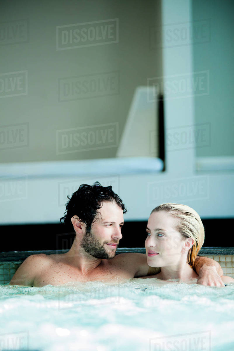 Couple relaxing together in jacuzzi Stock Photo Dissolve