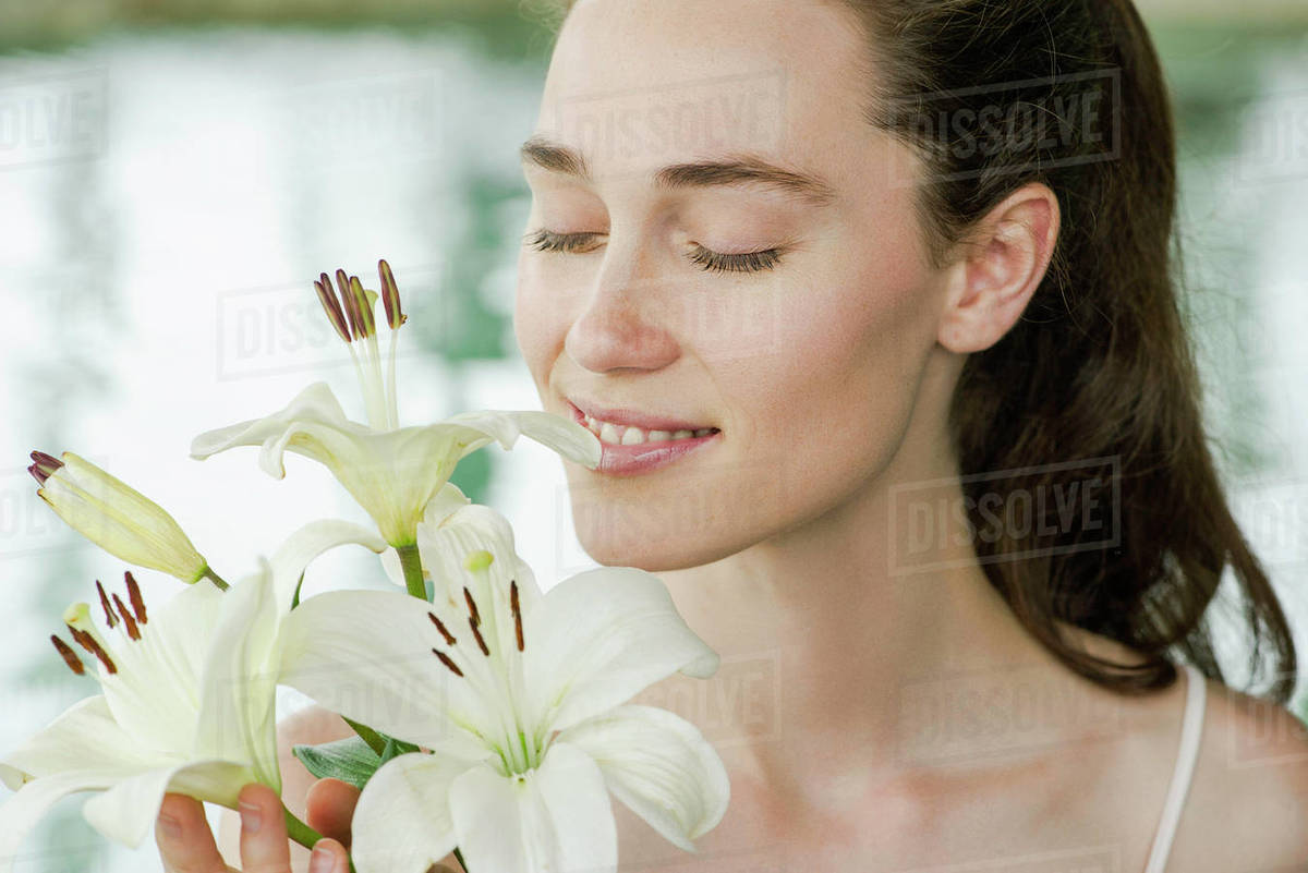 Young woman smelling lilies Stock Photo Dissolve