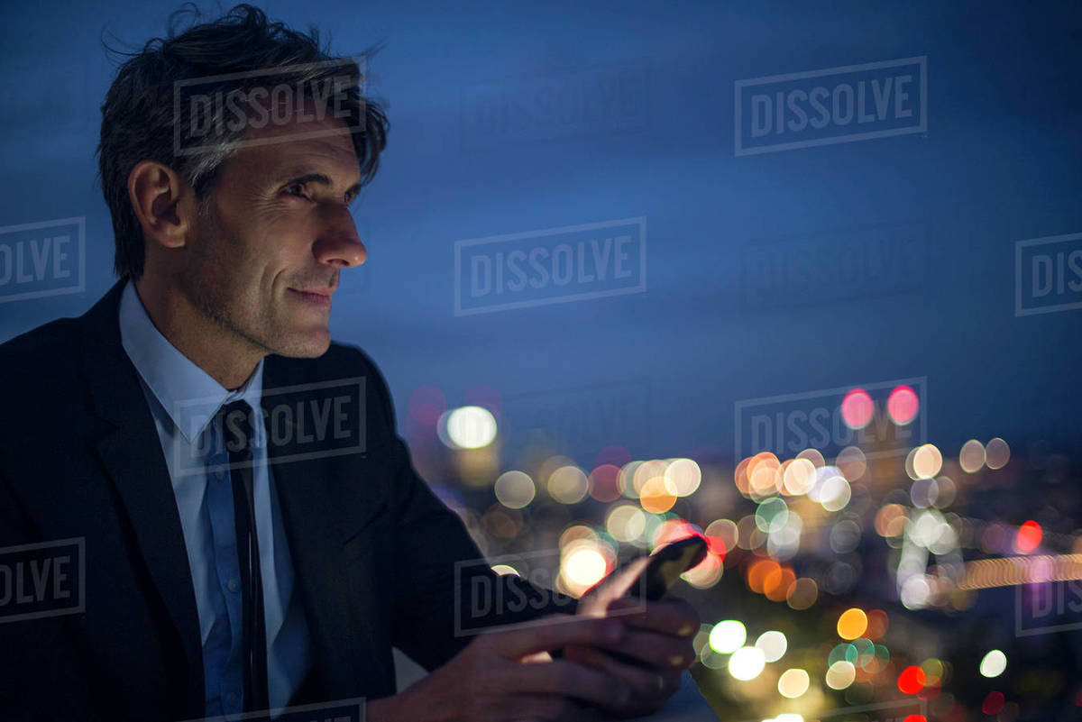 Businessman on high rise rooftop using mobile phone Royalty-free stock photo