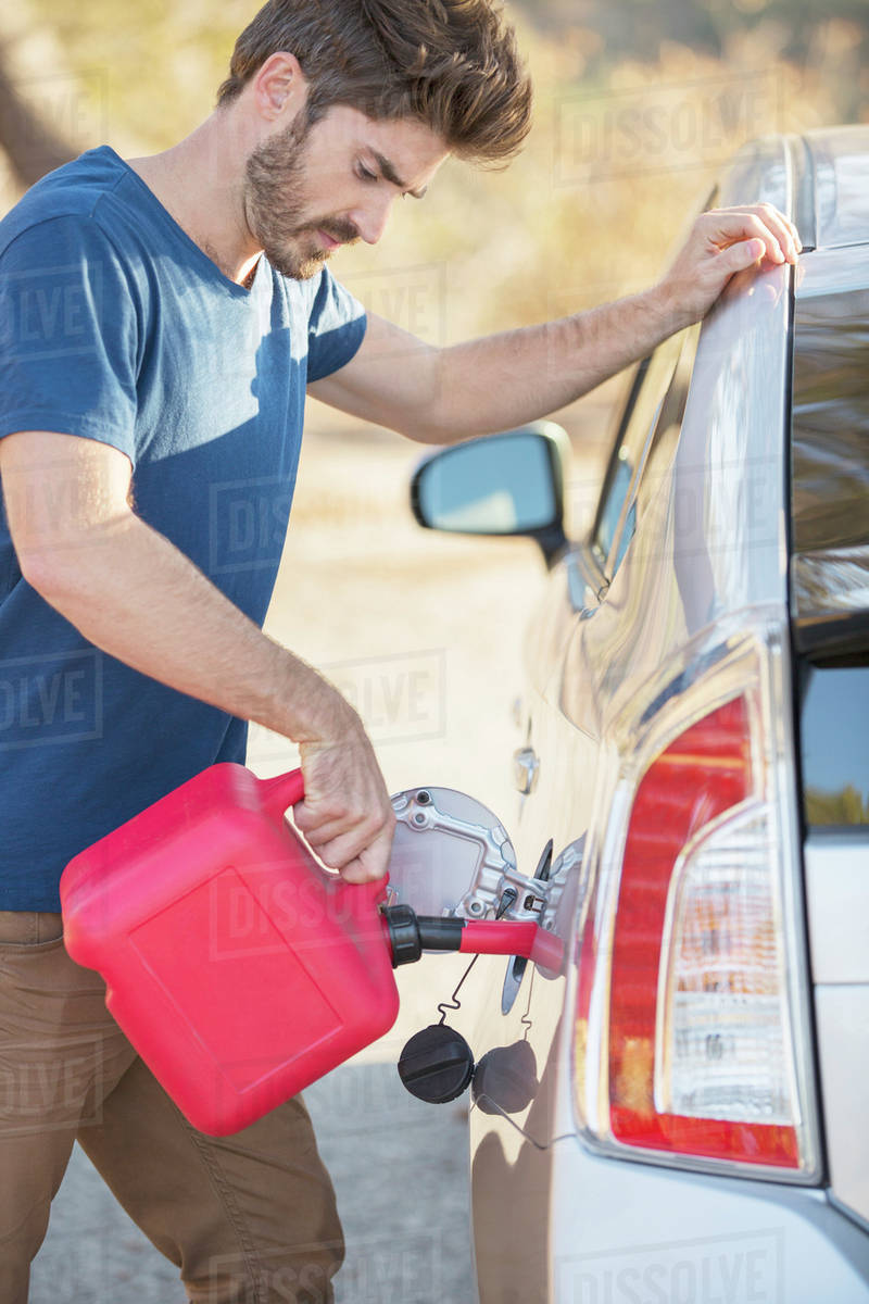 Man filling gas tank at roadside Stock Photo Dissolve