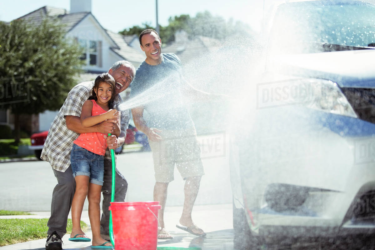 Multigeneration family washing car in driveway Stock Photo Dissolve