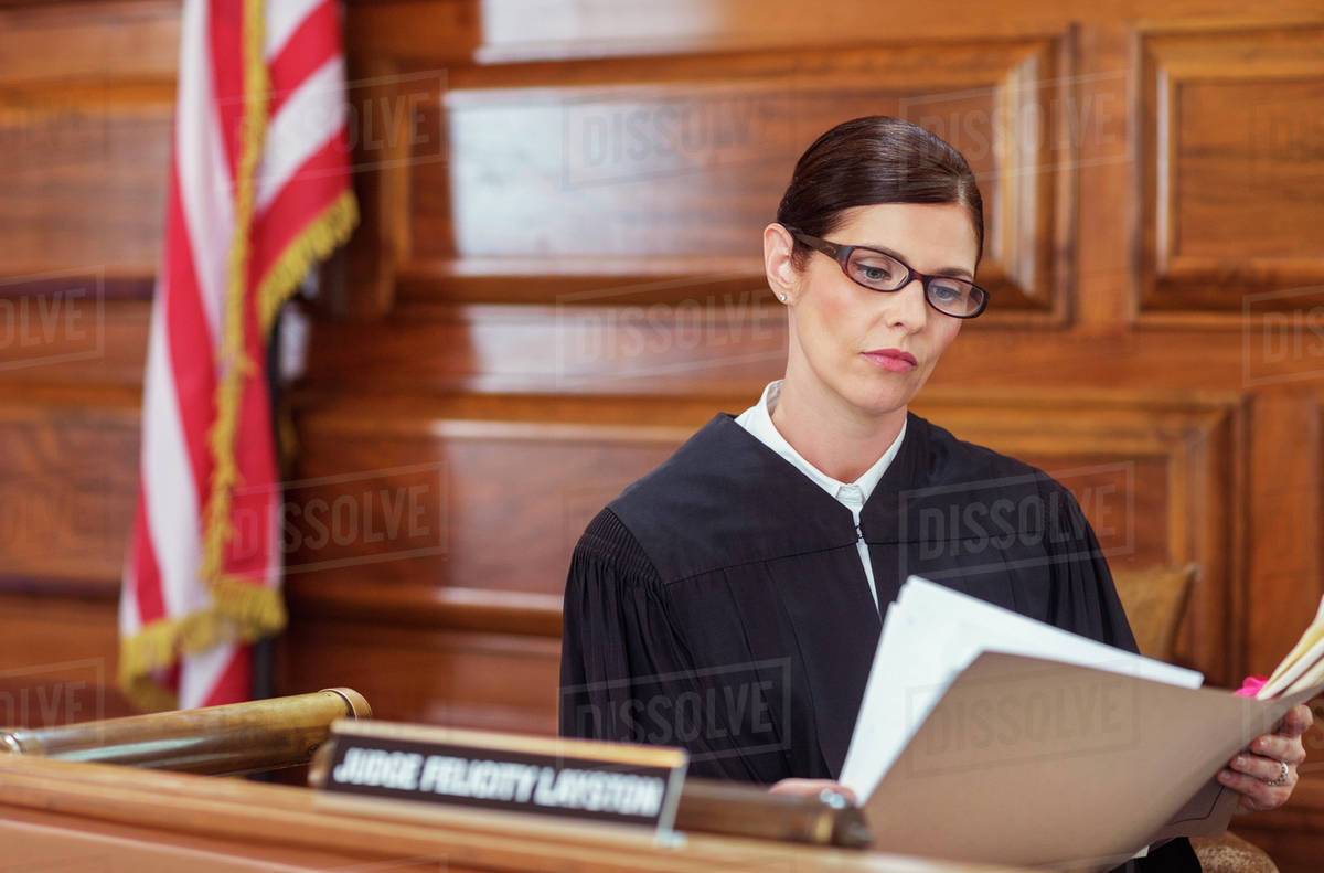 Judge looking through documents and judges bench Stock Photo Dissolve