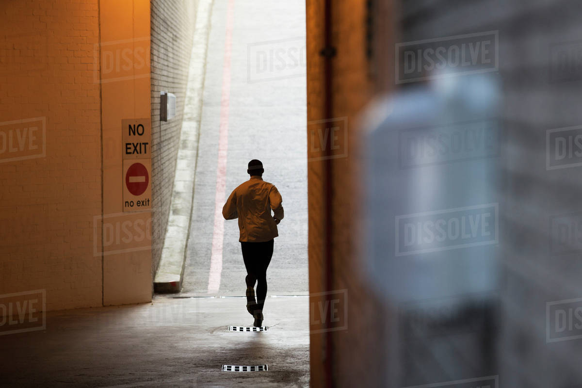 Man running through city streets Stock Photo Dissolve