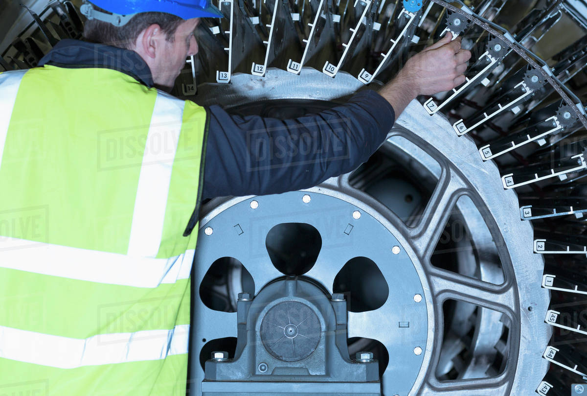 Engineer examining printing press machinery Stock Photo Dissolve