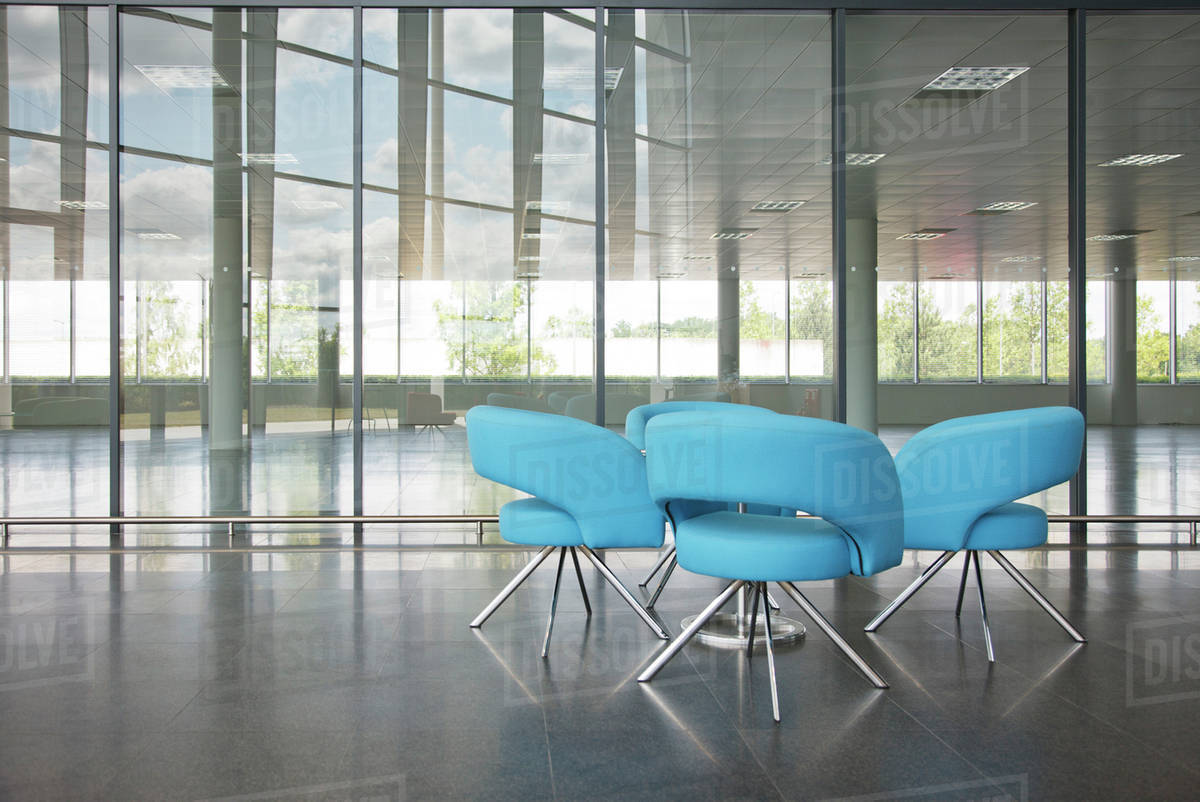 Chairs and table in office lobby area Stock Photo Dissolve