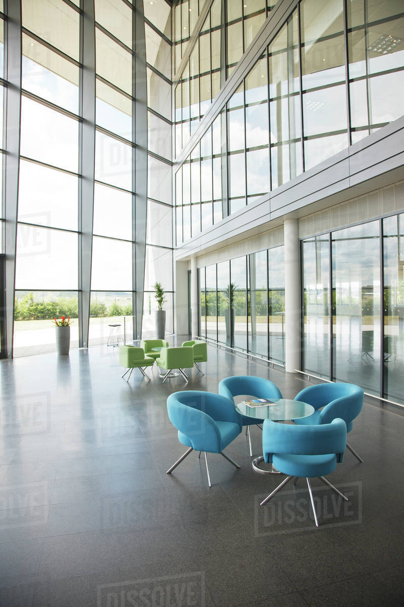 Chairs and table in office lobby area Stock Photo Dissolve