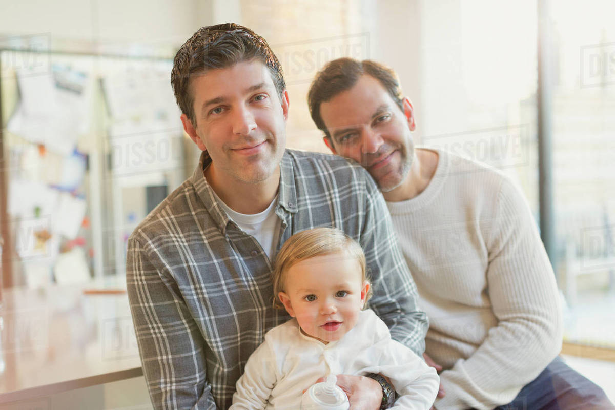 Portrait smiling male gay parents with baby son Royalty-free stock photo