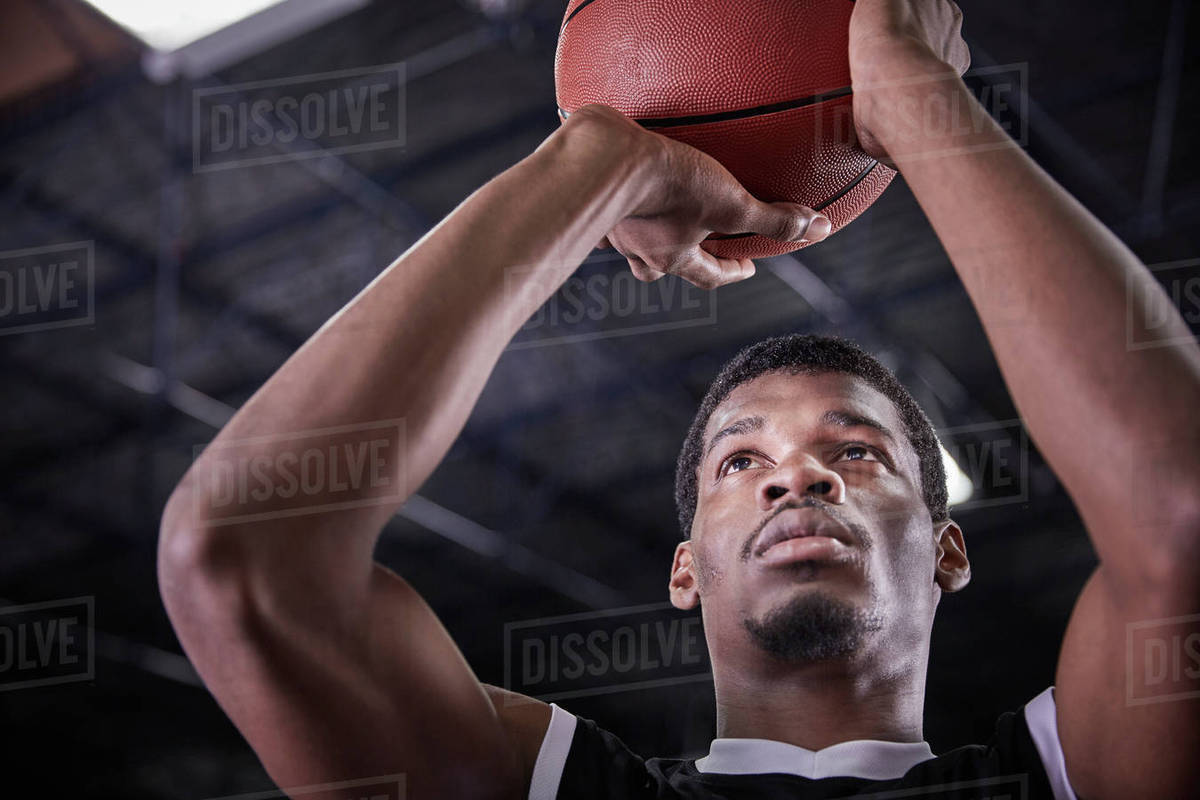 Focused young male basketball player shooting free throw Stock Photo