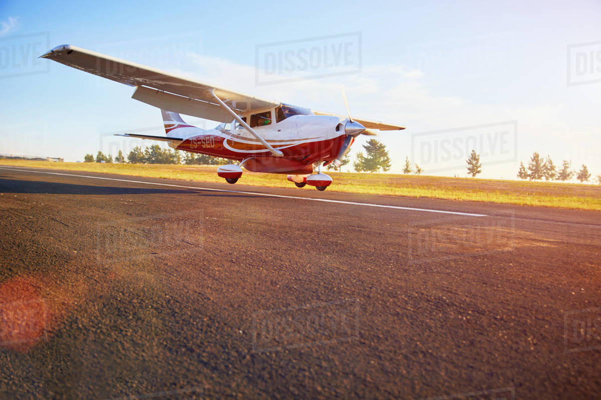 Prop airplane landing on sunny tarmac Stock Photo Dissolve