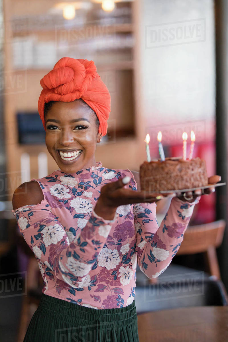 Portrait confident young woman carrying birthday cake Stock Photo