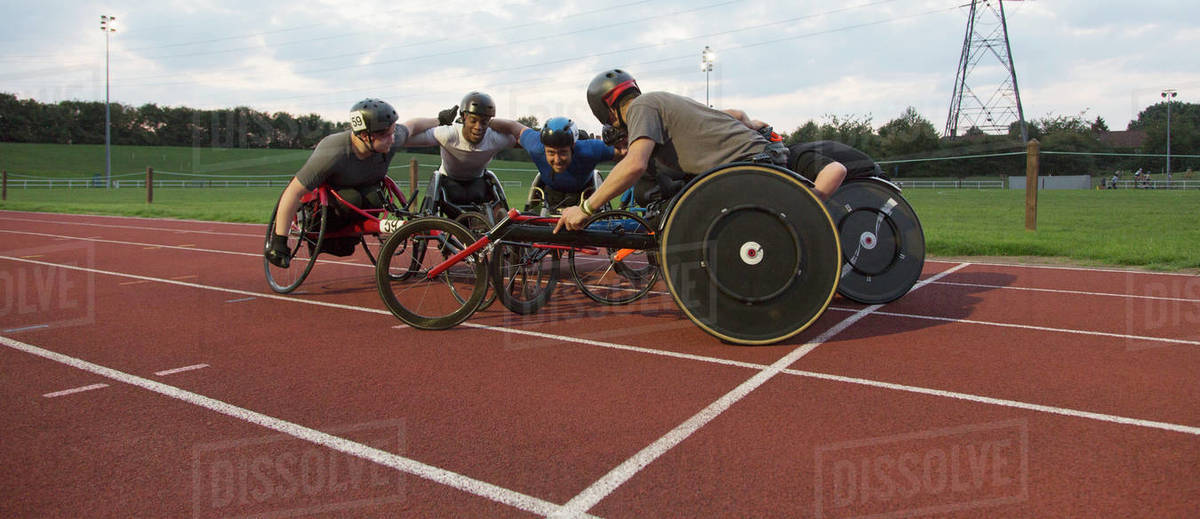 Determined paraplegic athletes bonding in huddle, training for