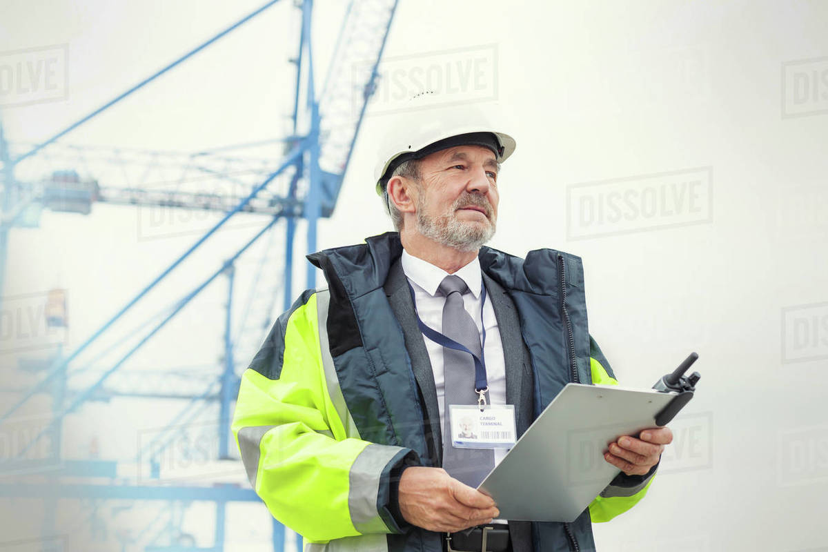 Dock manager with clipboard at shipyard Stock Photo Dissolve