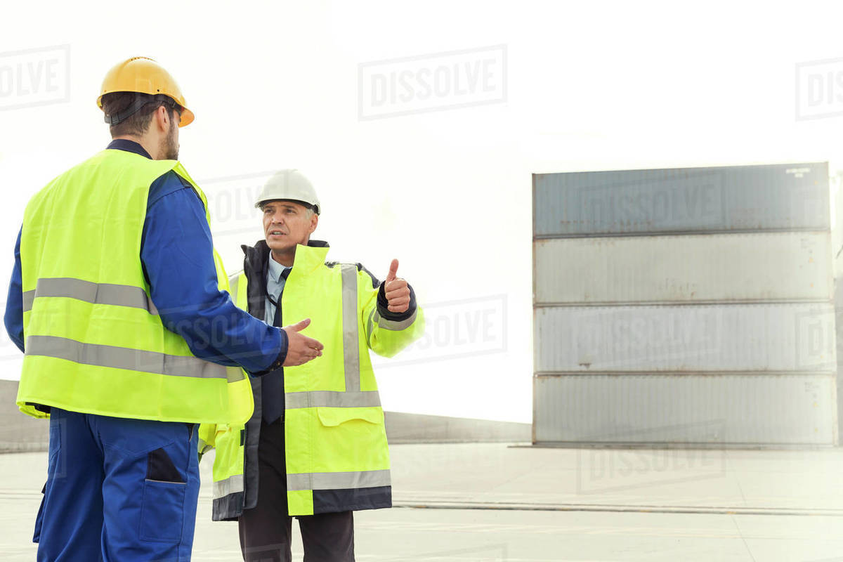 Dock worker and manager talking at shipyard Stock Photo Dissolve