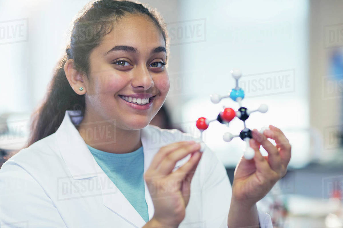 Portrait smiling girl student holding molecular model in laboratory