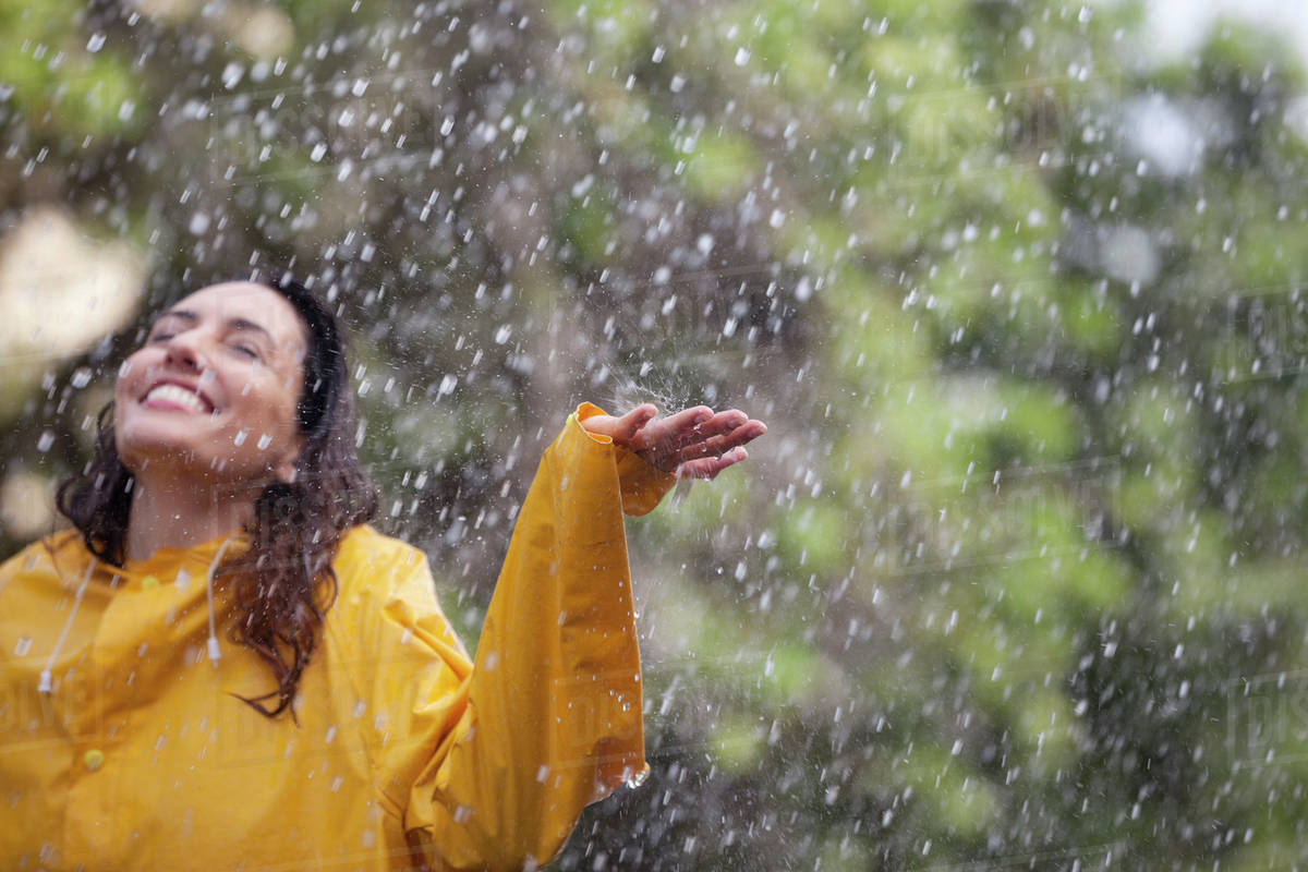 Happy woman standing with arms outstretched in rain Royalty-free stock photo