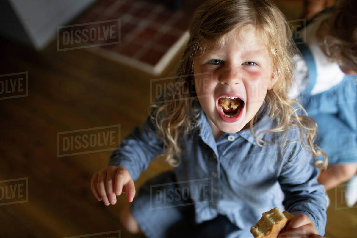Little girl showing food in mouth Stock Photo Dissolve