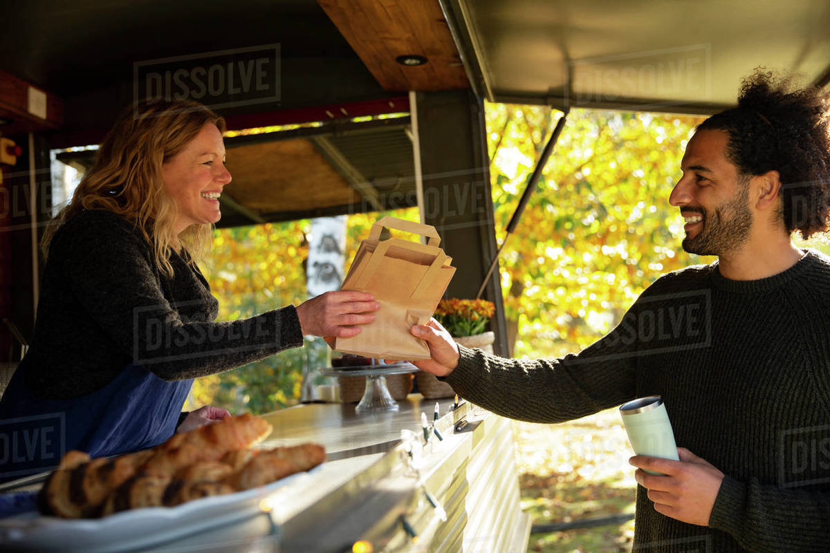 Friendly food cart owner serving customer Stock Photo Dissolve