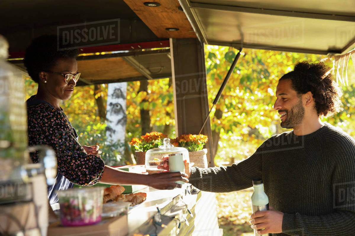 Food cart owner serving coffee to customer Stock Photo Dissolve