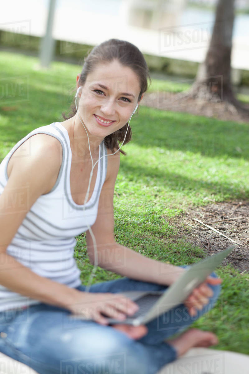 Happy girl using laptop outside Stock Photo Dissolve