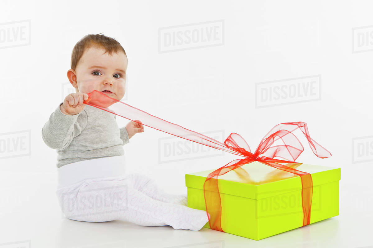 A baby girl opening a present Stock Photo Dissolve