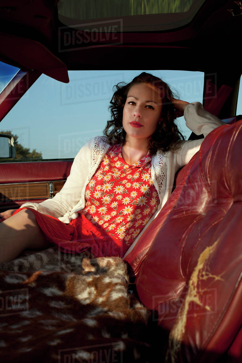 A pretty rockabilly woman sitting in the passenger seat of a